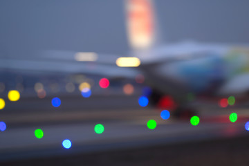 Flugzeug auf Rollbahn und bunte Lichter unscharf - Stockfoto