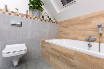Modern bathroom interior with gray tiles and wooden decors