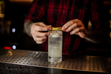 Barman decorating a glass of alcoholic lemonade drink