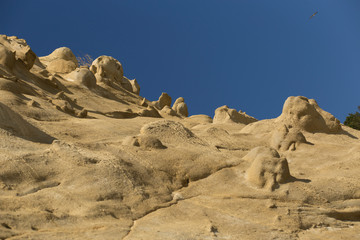 Fototapeta na wymiar Sand formations in the mountains of the Black Sea coast. Fantastic landscape of extraterrestrial origin. The remains of ancient fairy-tale creatures. Natural sculptures made by wind and water.