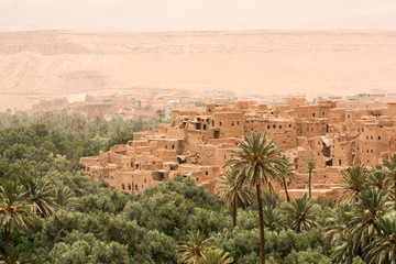 Fototapeta na wymiar Stadt in der Wüste mit Oase und Palmenhain in Marokko