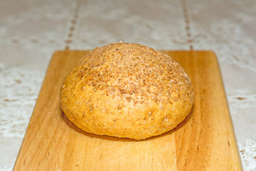 Bun with bran on a wooden board