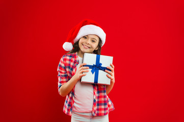 Little girl child in santa red hat. Christmas shopping. Present for Xmas. Childhood. New year party. Santa claus kid. Happy winter holidays. Small girl. Opening her Christmas present
