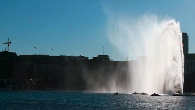 Alster Font&auml;ne Hamburg, Deutschland im Gegenlicht mit Wind und Gischt Wasserschleier