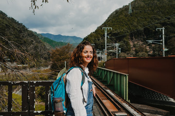 Young beautiful occidental woman discovering the nipon country. Waiting at the "romantic train" station that travels to Arashiyama in Kyoto. Travel photography.