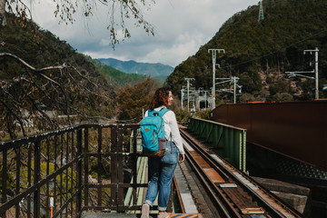 Young beautiful occidental woman discovering the nipon country. Waiting at the "romantic train" station that travels to Arashiyama in Kyoto. Travel photography.