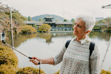 .Middle-aged occidental woman discovering the nipon country. Tourism in the temples and gardens of...