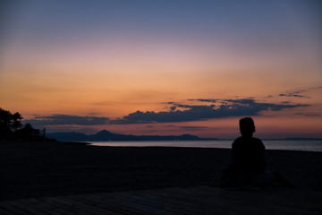 Träumerischer Sonnenuntergang mit person im gegenlicht silhouette am Meer in Denia in Spanien Valencia , dreamy sunset with silhouette on the beach in Denia Valencia in Spain