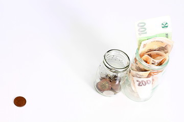 glass jars with coins and banknotes
