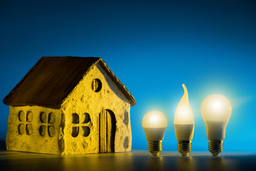 Silhouette led lamps against layout of the house on a blue background