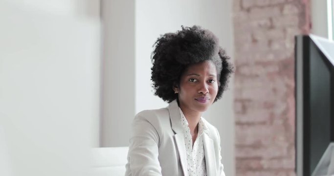 Portrait of a female african american business executive working in an office on a desktop computer