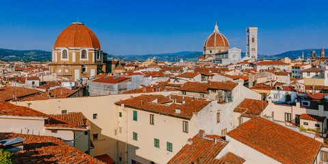 Florence Cathedral, Giotto's Bell Tower, and San Lorenzo Basilica under blue sky, over houses of the historical center of Florence, Italy