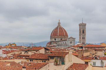 Fototapeta na wymiar Florence Cathedral and Giotto's Bell Tower, under overcast sky, over houses of the historical center of Florence, Italy
