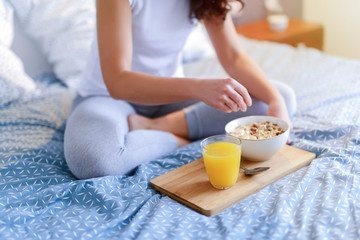 Obraz na płótnie Canvas Healthy morning breakfast in a bed. Blurred figure of woman holding tablet.