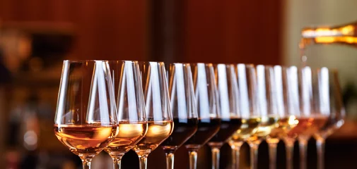 Fototapeten Weingläser in einer Reihe. Wein gießen. Buffet-Tischfeier der Weinprobe. Nachtleben, Feiern und Unterhaltungskonzept © Ekaterina_Molchanova
