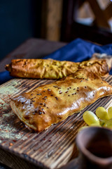 Traditional Georgian khachapuri on the table with grapes. Homemade baking recipe.