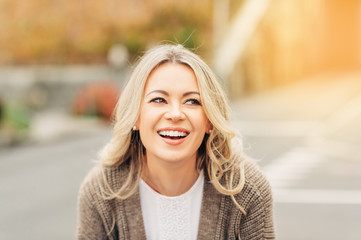 Outdoor portrait of happy smiling woman with blonde hair