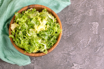 Fresh frisee salad in wooden bowl. Healthy food