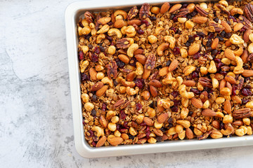  homemade granola made from oatmeal, raisins, honey,  blueberries, cranberry, flax, almond, macadamia, cashew, pecan, freshly baked .