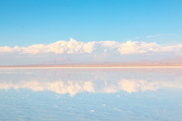 Salt Lake Uyuni in Bolivia. off road vehicle over a reflective salt flat ground.