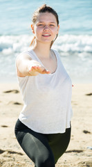 Portrait of sportswoman which is stretching in white T-shirt