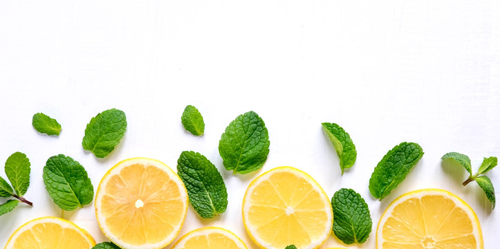 White background with lemon, orange slices and mint. Concept with fresh fruit. Lemon, Orange, Mint. View from above.