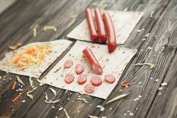 sausages, pickled cabbage and pita bread on wooden background