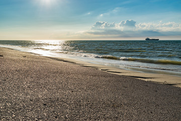 Nature, water, environment and paysage concept: view of the North Sea, ship in the background and clouds. © mimpki