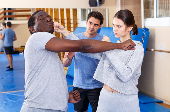People fighting with coach at gym