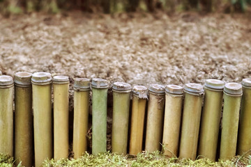 Low fence from reed around a bed against the background of the earth