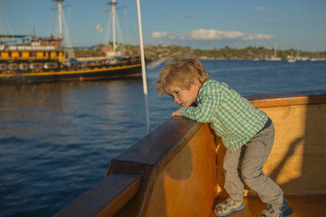 Boy on the deck of the ship. Sea holiday. Summer tourism. Little pirate. A child at sea. Cruise on the liner. Children's vacation adventures.