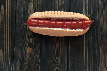 hot dog with smoked sausage on dark wooden background.photo with copy space
