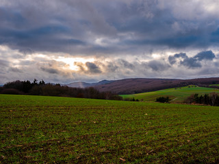 landscape of a valley with sun behind clouds in germany