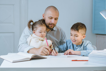 Father with his children have fun sitting at a table.