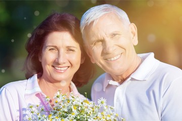 Close-up portrait of an elderly couple hugging in park