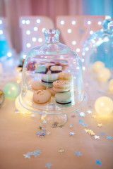 Delicious wedding reception candy bar dessert table full with cakes, sweets, macaroons, eclairs and other types of bakery