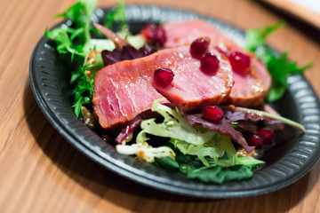 Slices of raw tuna with herbs and pomegranate