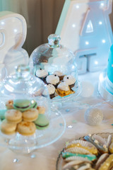 Delicious wedding reception candy bar dessert table full with cakes, sweets, macaroons, eclairs and other types of bakery