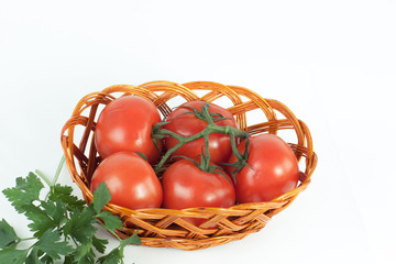 branch of ripe tomatoes in a wicker basket.isolated on white