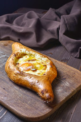 Ajarian traditional flatbread - khachapuri or hachapuri with egg and cheese. Copy text area for menu design or recipe book text.