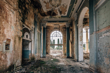Fototapeta na wymiar Ruined large hall interior overgrown by plants and moss