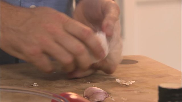 A man separating a garlic bulb into cloves
