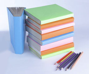 colored pencils and stack of books on white background. photo wi