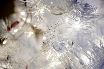 white christmas tree with red toys background close up warm led