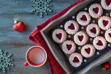 Top view of traditional Linzer cookies with red jam heart on dark background