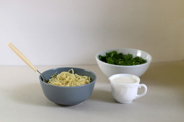 Bowls of lemony pasta, spinach and yoghurt sauce. Selective focus. 