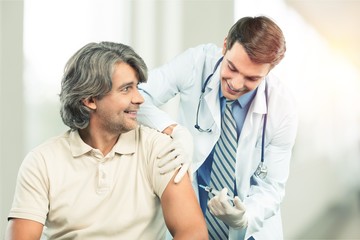 Obraz premium Handsome doctor making vaccination to male patient