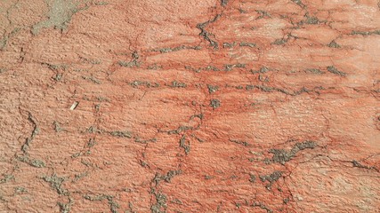 Red colored damaged road or paved pathway with crackes