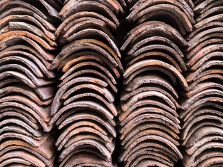 Background of columns of clay tiles stacked in a pile, for roof construction