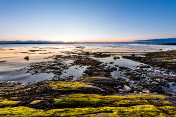 Sunset, dusk in Rimouski, Quebec, Saint Lawrence river, Gaspesie, Canada with rocks, boulders,...